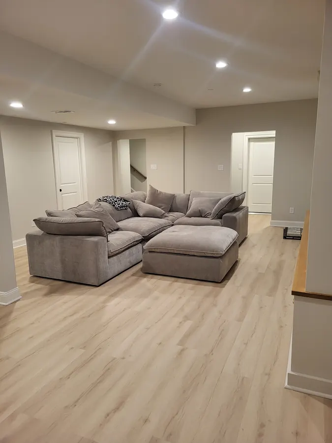 Finished basement family room with sectional sofa and recessed lighting